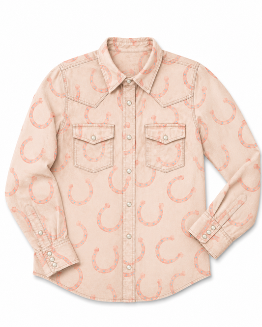 A light peach-beige western-style button-up shirt with an allover coral-pink horseshoe print, featuring two chest pockets and a pointed collar, shown on a plain white background.