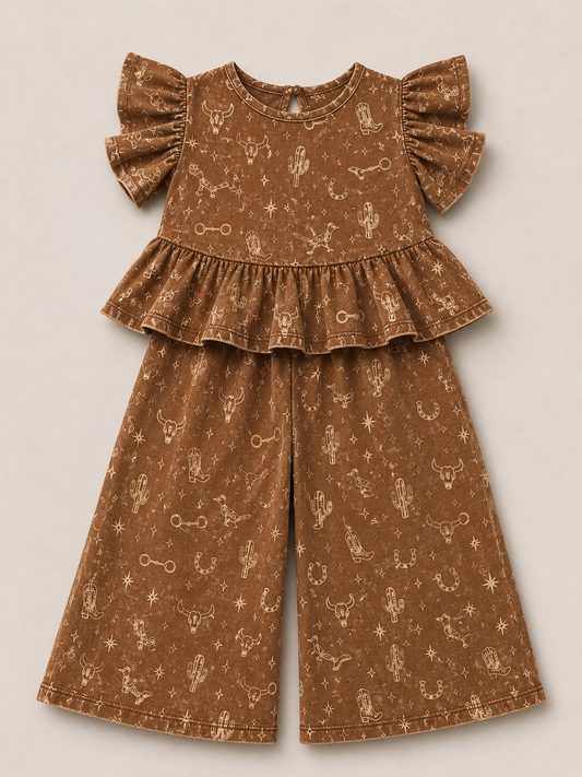 A two-piece outfit set in a brown fabric with a light beige western-themed print of cacti, stars, and bones. The set includes a short-sleeve top with ruffled shoulders and a matching pair of wide-leg pants, laid flat on a neutral beige background.