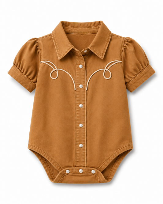 A baby romper styled like a western shirt, made from a warm camel-colored cotton fabric with puff sleeves, a pointed collar, snap-button front, and white embroidered details on the chest.