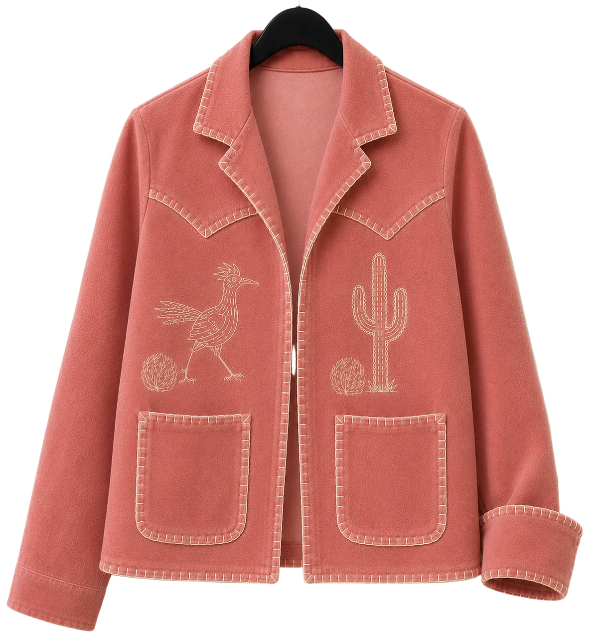 A dusty rose pink suede blazer jacket with white contrast stitching, featuring embroidered designs of a road runner and a cactus on the front, hanging on a black hanger against a white paneled wall.
